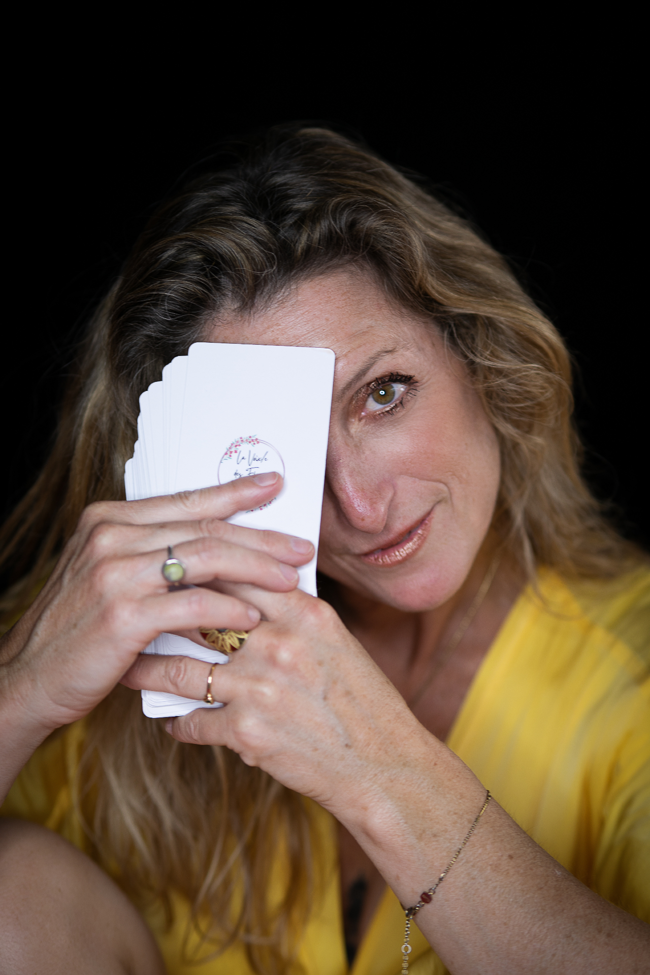 Marie Donzé, créatrice de La Voix/e des Fleurs, tenant son jeu de Cartes Médecine des Fleurs de Bach